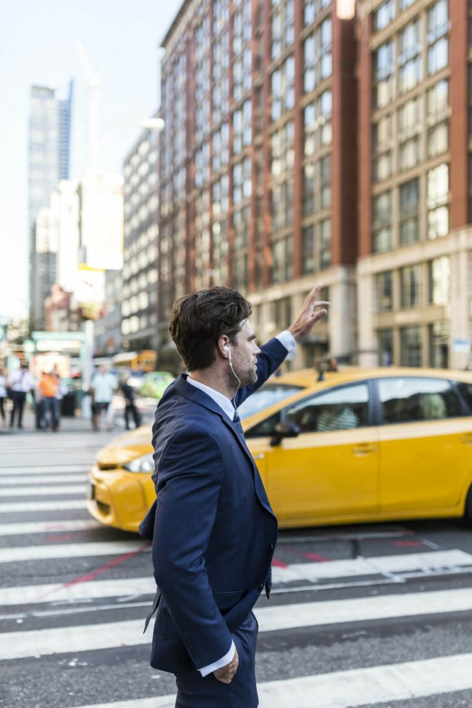 Businessman in the streets of manhattan hailing a cab.jpg